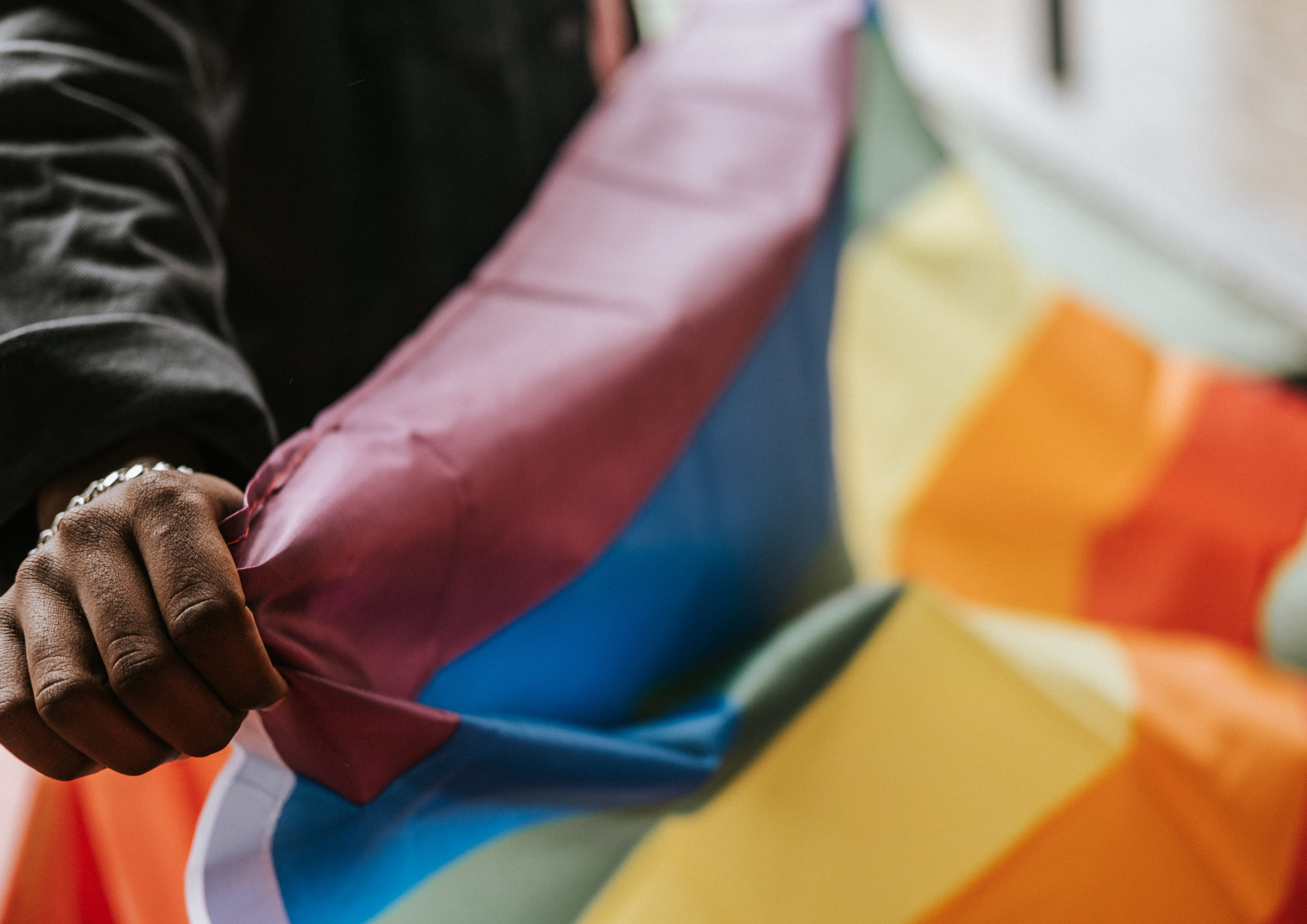 pessoas segurando bandeira lgbtqia
